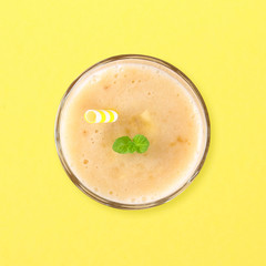 Banana smoothies on a yellow pastel background, minimalism, flat lay, top view.