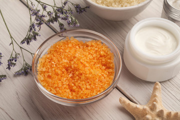 Orange sea salt and face cream on white wood