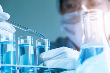 Researcher with glass laboratory chemical test tubes with liquid for analytical , medical, pharmaceutical and scientific research concept.