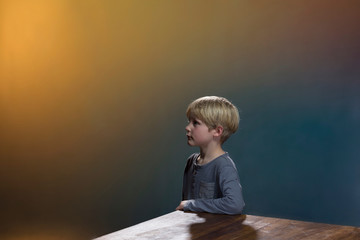 Boy at table, gold and blue background