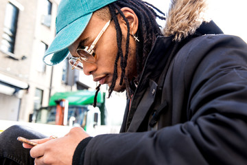 Man with dreadlocks looking at smartphone