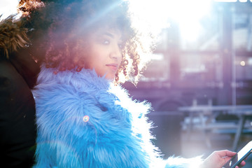 Portrait of woman with afro and fur coat looking away