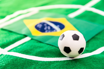 Brazil flag and soccer ball on green grass field