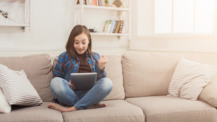 Happy girl with digital tablet at home