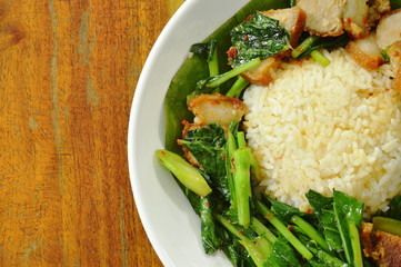 stir fried Chinese kale with crispy pork and rice on plate