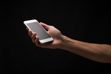 Male hand holding mobile smartphone with blank screen