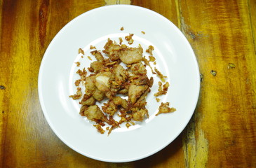 fried fermenting pork bone with garlic and pepper on white plate