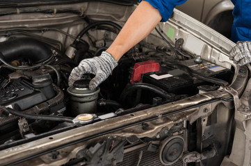 mechanic is using hand to open the engine cover for checking engine