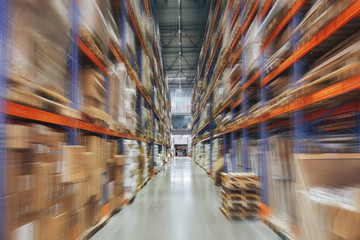 Large Logistics hangar warehouse with lots shelves or racks with pallets of goods, perspective with motion blur effect
