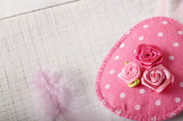 Handmade patchwork pink and lilac felt easter eggs on white wooden table