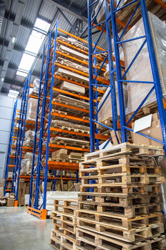 Large Logistics hangar warehouse with lots shelves or racks with pallets of goods. Industrial shipping and cargo delivery