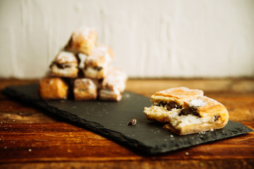 Strudel Apple and sugar powder. Biscuit from the puffed Test on the Gray Background. Dessert with Fruits.Copy space for Text. selective focus.