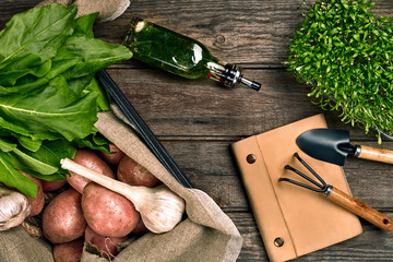 Fresh potatoes, oil, garlic and spicy herbs on a kitchen wooden background. Fresh vegetables from...