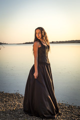 Girl in black dress by water