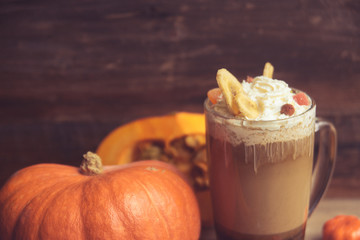 Pumpkin smoothie, spice latte. Boozy cocktail with whipped cream on top on a wooden background. Copy space Top view
