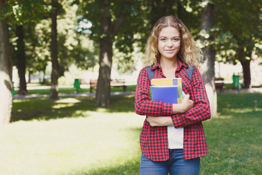 Happy female student standing in the park
