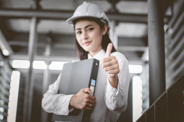 Female architect at a construction site looking happy