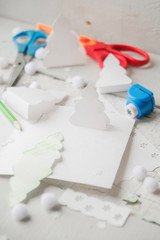 Creative paper Christmas tree on white paper sheet, scissors and colorful crayons on color table background