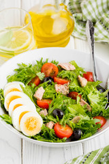 Salad with tuna, egg, cherry tomatoes, olives, oil