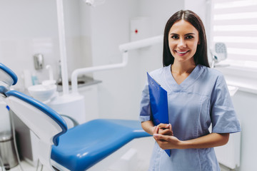dentist with clipboard at working place