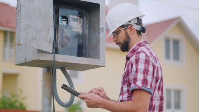 The inspector checks the meter reading. Records the testimony in the tablet
