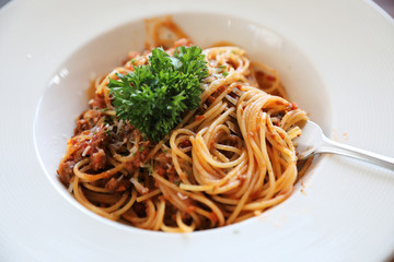 spaghetti Bolognese with minced beef and tomato sauce garnished with parmesan cheese and basil , Italian food