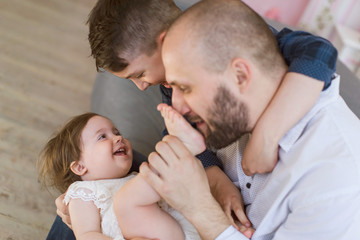 Dad and two children have a fun at home.