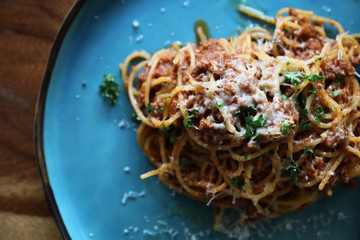 spaghetti Bolognese with minced beef and tomato sauce garnished with parmesan cheese and basil , Italian food top view