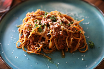 spaghetti Bolognese with minced beef and tomato sauce garnished with parmesan cheese and basil , Italian food