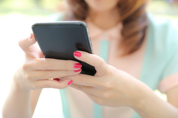 Female hand with smartphone trading stock online in coffee shop , Business concept