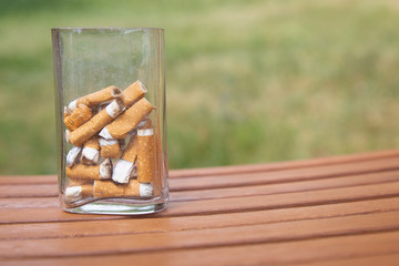 Cigarette butts in white glass ashtray