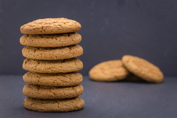 Fototapeta na wymiar Stack of seven home made cookies - oat cookies on the background of black slate
