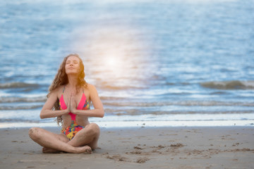 Fototapeta na wymiar Young healthy woman with blonde curly hair doing yoga on the beach, Summer beach vacation and relaxing concept.