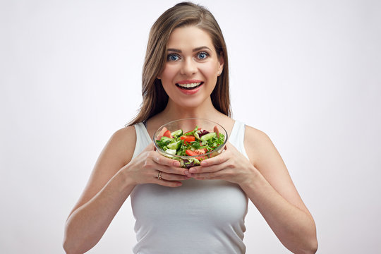 Young positive woman holding salad bowl.