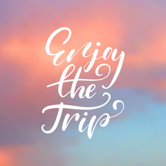 Enjoy the trip - handwritten lettering, summer holiday quote on abstract blur unfocused sky backdrop