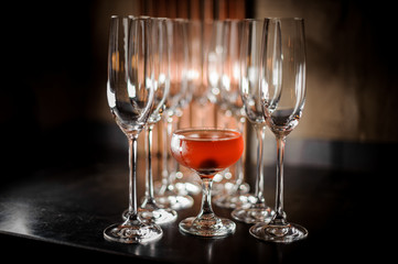 Delicious cocktail standing among empty champaigne glasses