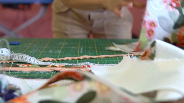 The dressmaker's desk. The tailor works with a jacquard cloth.