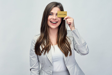 Smiling business woman holding credit card near face.