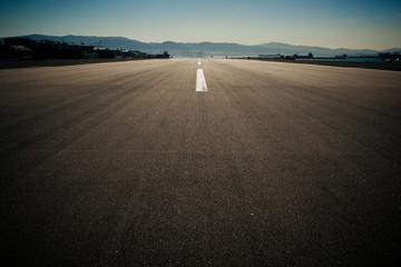 Runway of the Gibraltar airport in the evening. Photo with strong vignette and retro color grading.