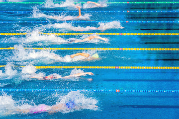 Young swimmers in outdoor swimming pool during competition. Health and fitness lifestyle concept...