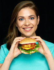 Smiling girl holding burger ready to bite fast food king.