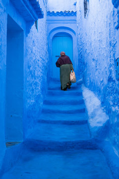 Old Woman Climbing The Blue Stairs