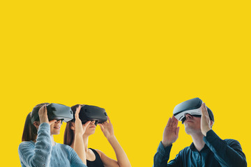 Young girls and a young guy in virtual reality glasses. The concept of modern technologies and technologies of the future. VR glasses