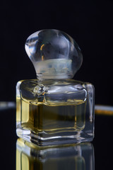 Fototapeta na wymiar Yellow bottle of perfume spraying, isolated on black background