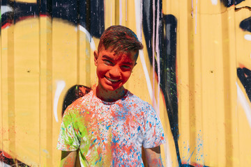 Fototapeta na wymiar Teen smiling, is painted colorful with a graffiti