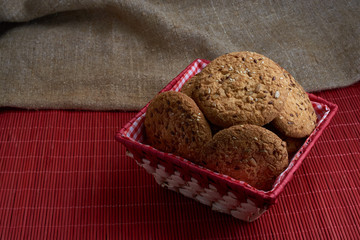 Savory cookies sprinkled with sesame seeds, sunflower on table and burlap background