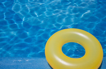 Fototapeta na wymiar Yellow floating ring on blue water pool.
