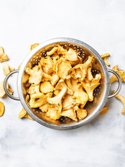 Forest mushrooms chanterelle in a steel colander, gray background, top view