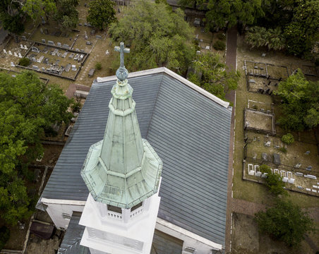 Aerial closeup view of church steeple and cross.