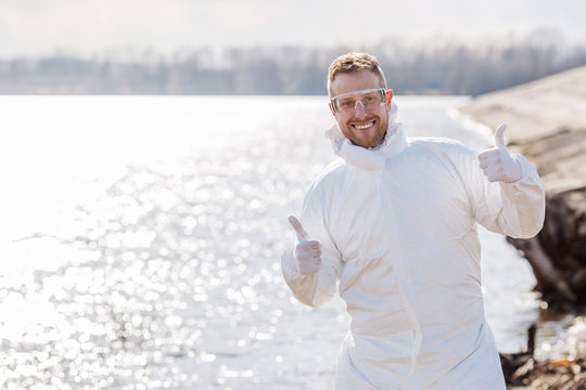 Ecologist working on dirty beach of the lake.